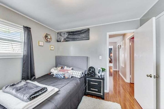 bedroom with ornamental molding and hardwood / wood-style floors