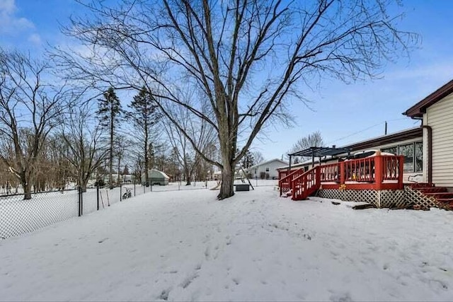 yard covered in snow featuring a wooden deck