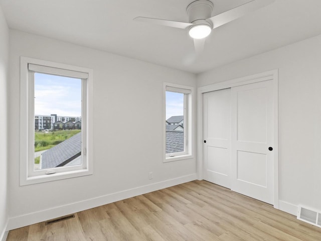 unfurnished bedroom with ceiling fan, a closet, and light hardwood / wood-style flooring