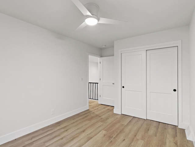 unfurnished bedroom featuring ceiling fan, light hardwood / wood-style floors, and a closet