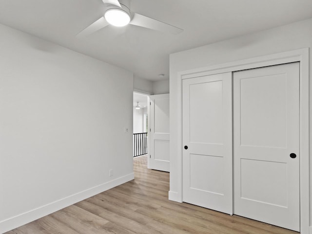 unfurnished bedroom with ceiling fan, a closet, and light hardwood / wood-style flooring