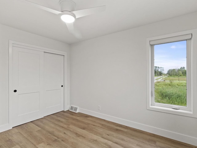 unfurnished bedroom featuring a closet, ceiling fan, and light wood-type flooring