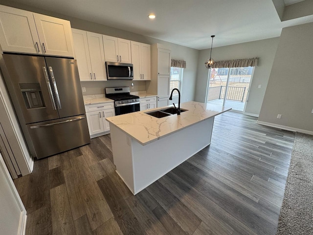 kitchen with sink, white cabinetry, decorative light fixtures, a center island with sink, and stainless steel appliances