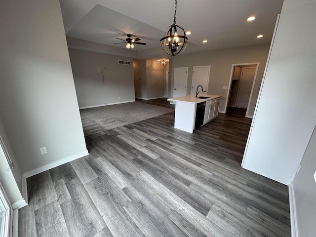 kitchen with dark wood-type flooring, sink, dishwasher, an island with sink, and pendant lighting