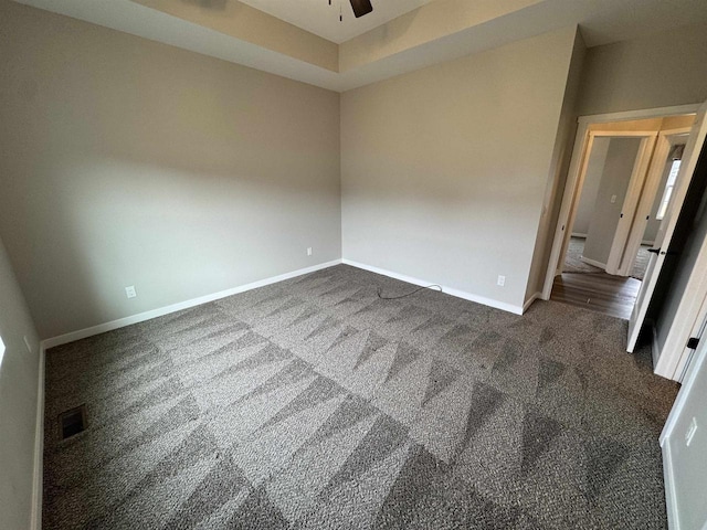 unfurnished room featuring ceiling fan and dark carpet