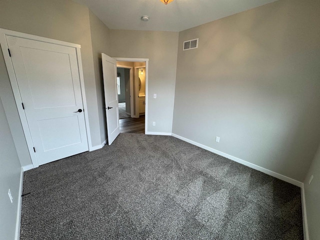 unfurnished bedroom featuring dark colored carpet