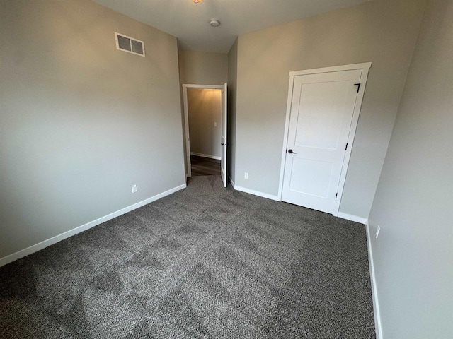 unfurnished bedroom with dark colored carpet