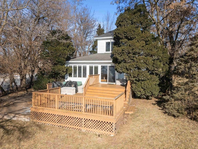 rear view of property featuring a deck and a sunroom