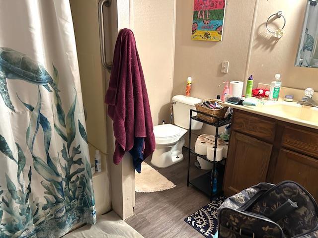 full bathroom with vanity, hardwood / wood-style floors, shower / bath combination with curtain, and toilet