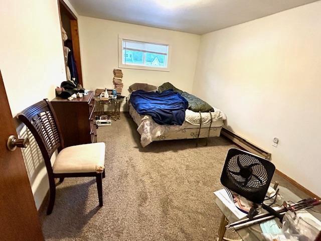 carpeted bedroom with a baseboard radiator