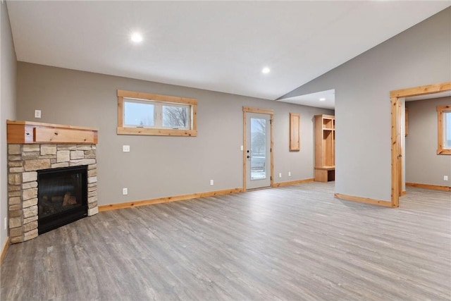 unfurnished living room featuring light hardwood / wood-style flooring, a fireplace, and vaulted ceiling