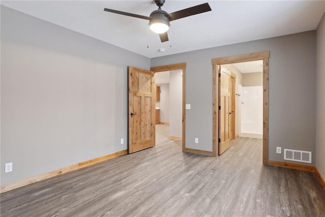 unfurnished bedroom with connected bathroom, ceiling fan, and light hardwood / wood-style floors