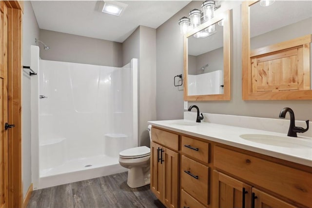 bathroom with vanity, hardwood / wood-style floors, toilet, and walk in shower