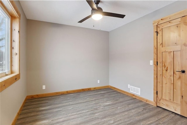 spare room with wood-type flooring, a wealth of natural light, and ceiling fan