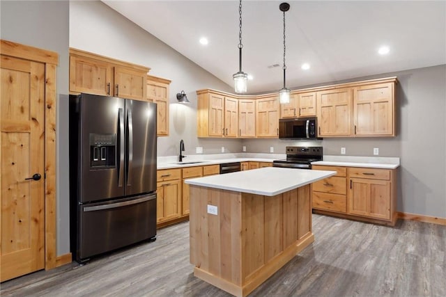 kitchen with sink, hanging light fixtures, black appliances, a kitchen island, and vaulted ceiling