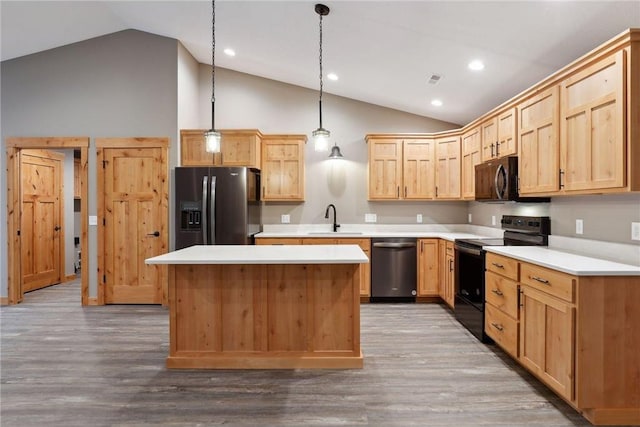 kitchen with sink, hanging light fixtures, a kitchen island, hardwood / wood-style floors, and black appliances