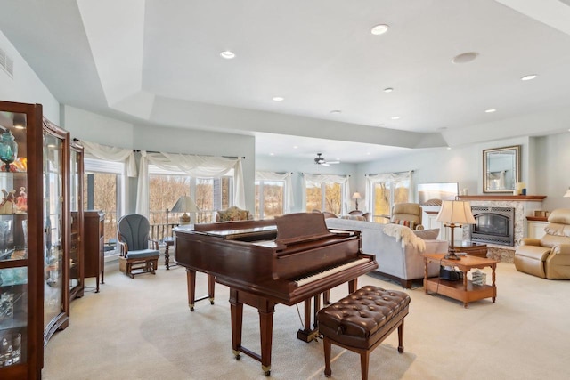 interior space featuring recessed lighting, a glass covered fireplace, and light colored carpet