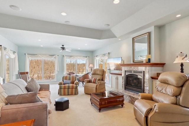 living area featuring a ceiling fan, recessed lighting, light colored carpet, and a premium fireplace