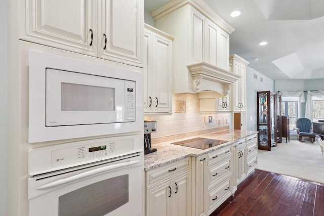 kitchen featuring recessed lighting, white appliances, white cabinetry, decorative backsplash, and light stone countertops