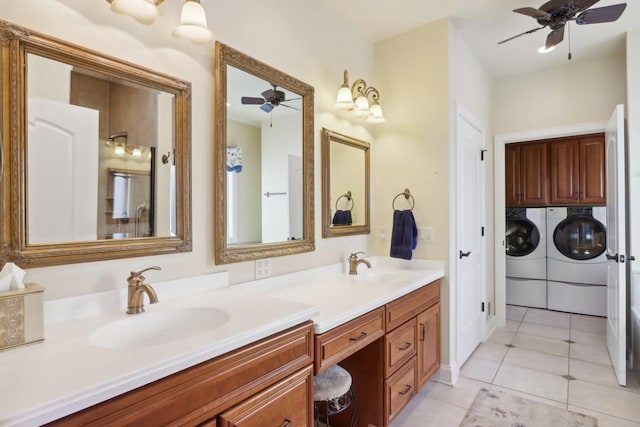 bathroom with ceiling fan, a sink, washer and clothes dryer, and double vanity