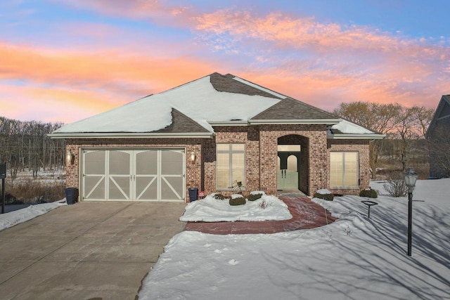 view of front facade with a garage, concrete driveway, and brick siding