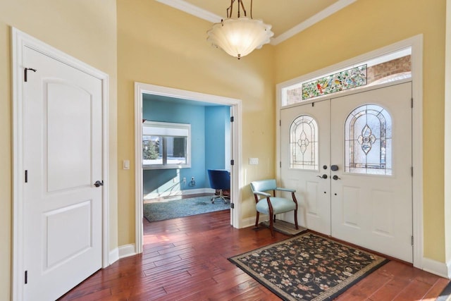 entryway with dark wood-style floors, baseboards, and crown molding