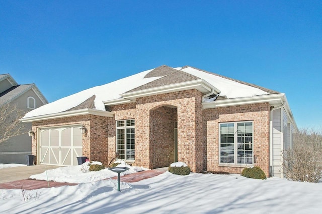 single story home with a garage and brick siding