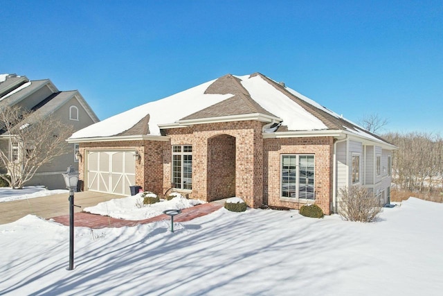 view of front facade with a garage and brick siding