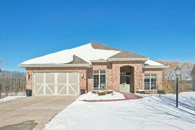 view of front facade featuring a garage, brick siding, and driveway