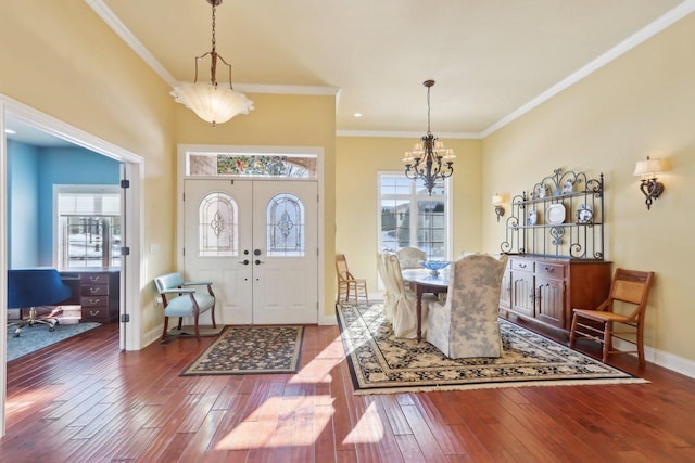 foyer entrance featuring ornamental molding, an inviting chandelier, wood finished floors, and baseboards