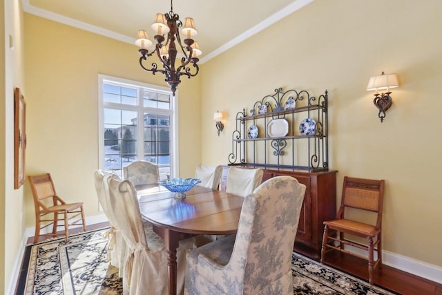 dining space with baseboards, a chandelier, crown molding, and wood finished floors