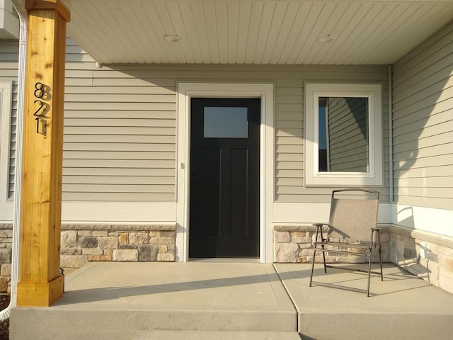 property entrance with stone siding and covered porch