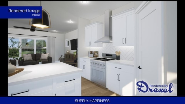 kitchen featuring white cabinets, wall chimney exhaust hood, light countertops, white gas stove, and pendant lighting