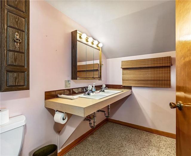 bathroom with lofted ceiling and toilet