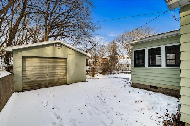 yard layered in snow with a garage and an outdoor structure