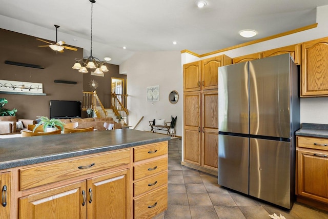 kitchen featuring freestanding refrigerator, vaulted ceiling, dark countertops, decorative light fixtures, and open floor plan