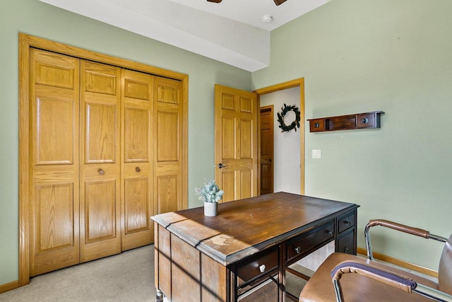 home office featuring light colored carpet, baseboards, and a ceiling fan