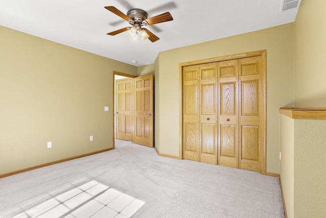 unfurnished bedroom with visible vents, light carpet, a closet, baseboards, and ceiling fan