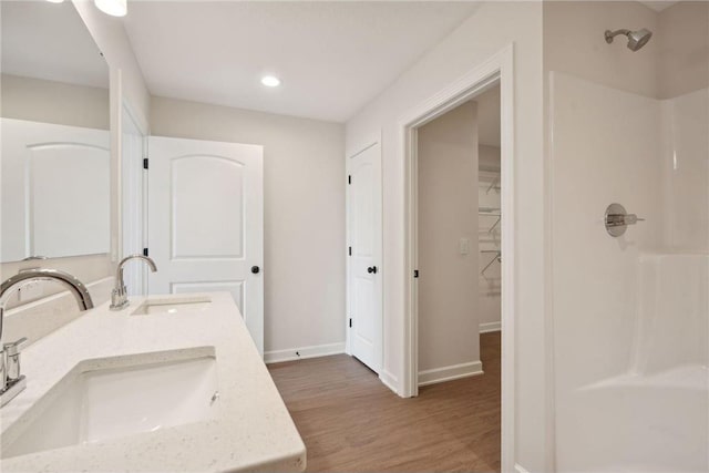 bathroom featuring hardwood / wood-style flooring, vanity, and a shower