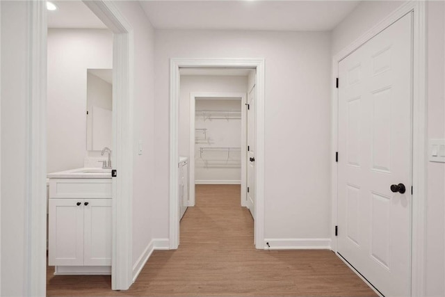 corridor featuring sink and light hardwood / wood-style floors