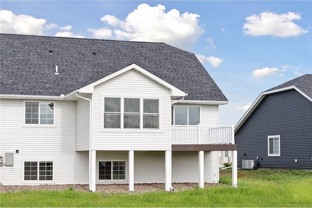 back of property with central AC and a lawn