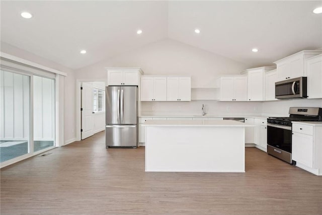 kitchen with white cabinetry, stainless steel appliances, and a kitchen island