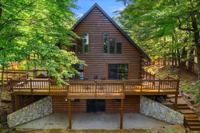 rear view of property with a deck and a patio area