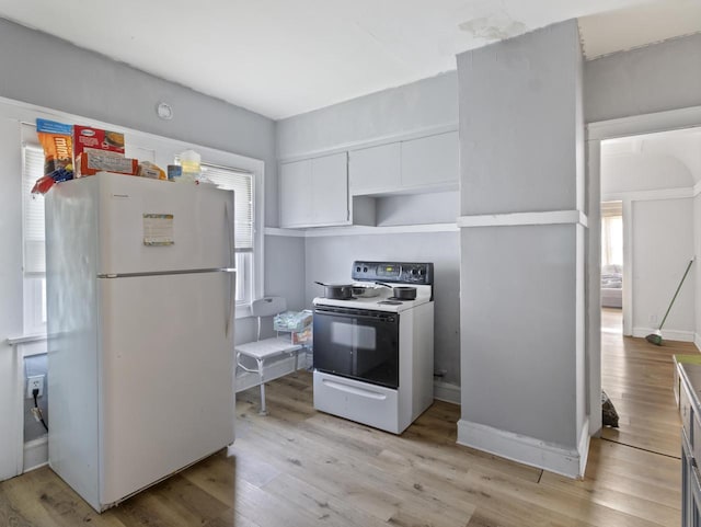 kitchen featuring white cabinetry, white fridge, light hardwood / wood-style floors, and electric stove