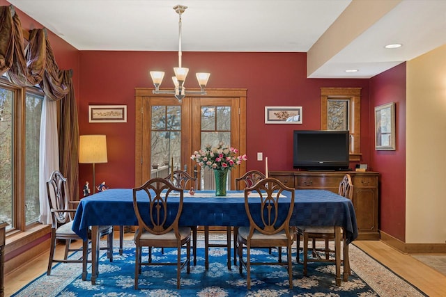 dining area with wood-type flooring and a notable chandelier