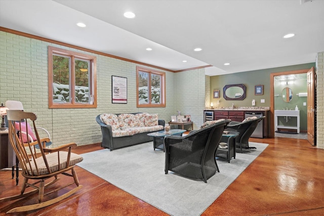 living room featuring sink, beverage cooler, and brick wall