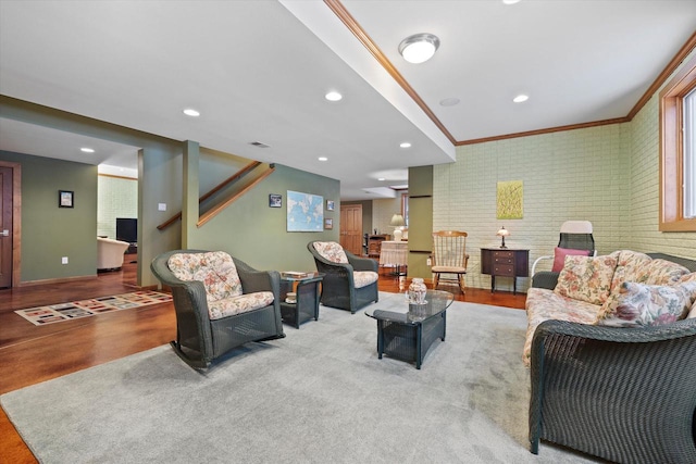 living room featuring crown molding and brick wall