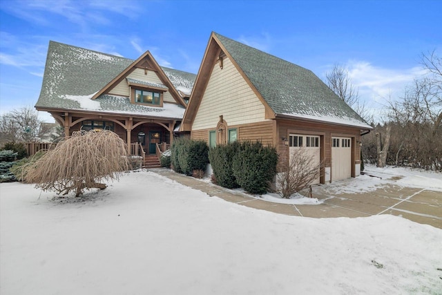 view of snow covered exterior featuring a garage and covered porch