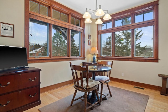 dining room featuring an inviting chandelier and light wood-type flooring