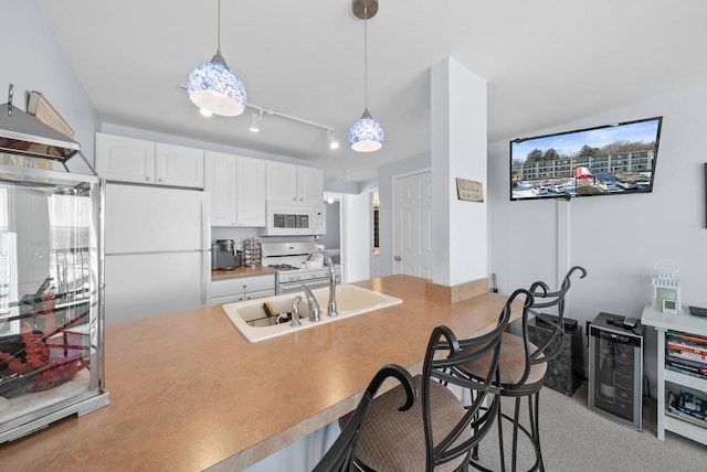 kitchen featuring pendant lighting, white cabinetry, sink, a breakfast bar area, and white appliances